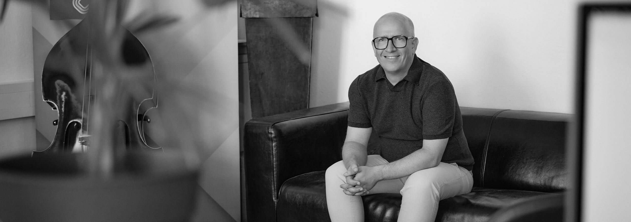 Horst Köpfelsberger, Designer, sitzt auf der Couch in der Agentur DEsignkraft.