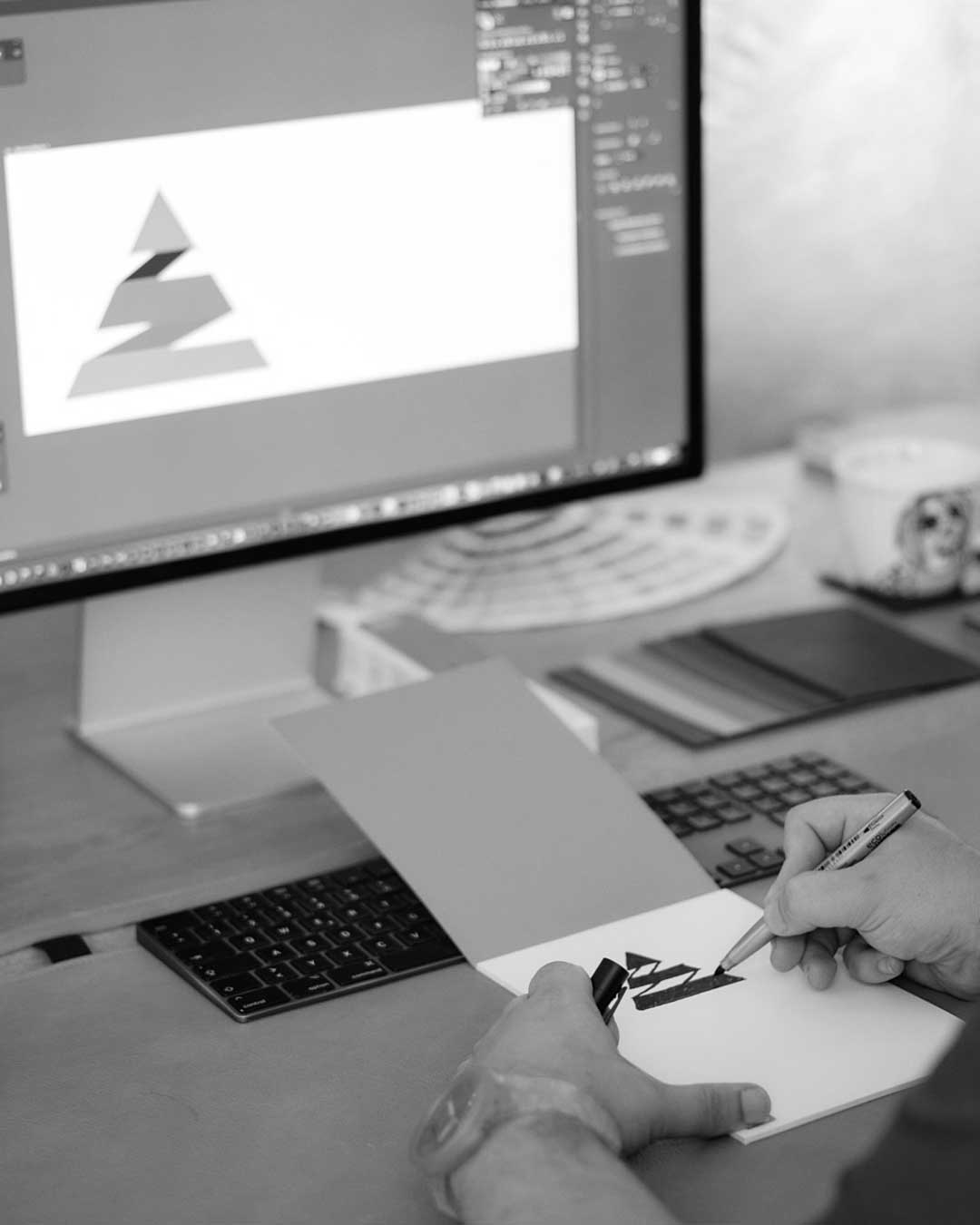 Skizze Logo auf Bildschirm und Skizzenblock bei DEsignkraft