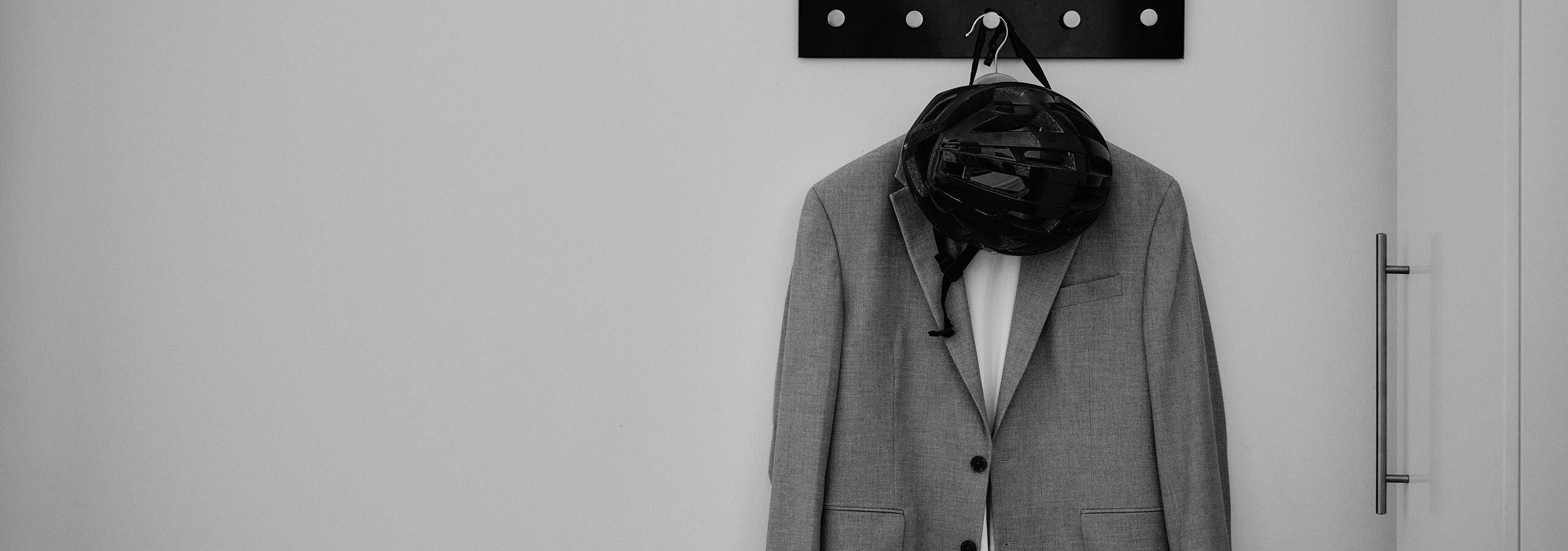 Fahrradhelm und Sakko hängen auf eienr Garderobe im Büro Designkraft